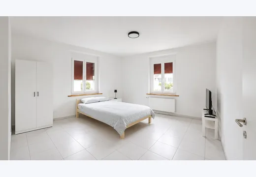 Möbliertes Zimmer mit Bett und TV