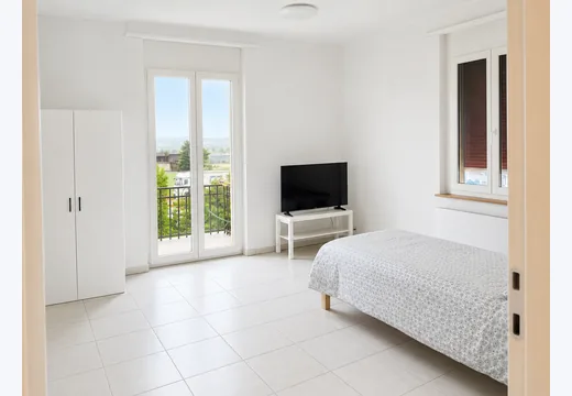 Helles Zimmer mit TV und Balkonzugang
